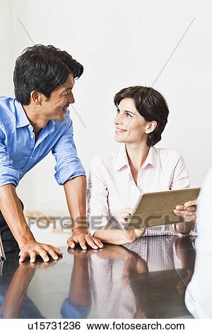 Business people talking at desk View Large Photo Image Stock Photograph - Business people talking at desk. Fotosearch
