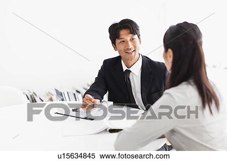 Stock Photography - Business people talking at desk. Fotosearch