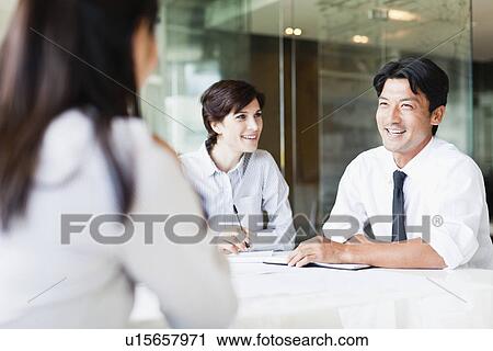 Stock Image - Business people talking in meeting. Fotosearch