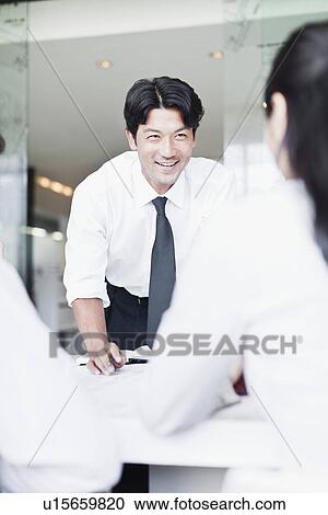 Stock Image - Business people talking in meeting. Fotosearch