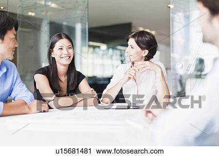 Stock Image - Business people talking in meeting. Fotosearch