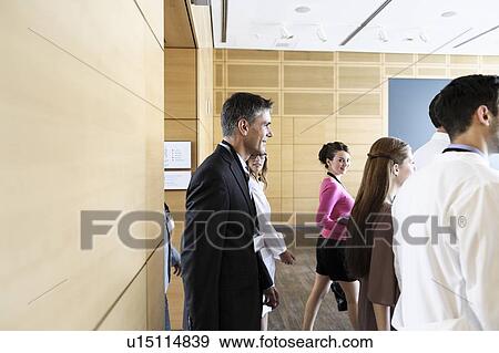 Stock Photo - Business people walking into conference. Fotosearch