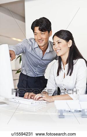 Business people working together at desk View Large Photo Image Stock Image - Business people working together at desk. Fotosearch