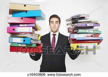 Businessman balancing stacks of folders View Large Photo Image Stock Photograph - Businessman balancing stacks of folders. Fotosearch