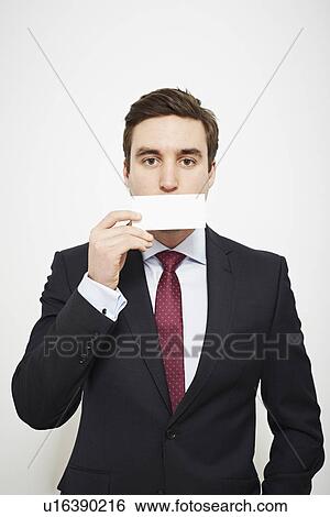 Stock Photograph - Businessman holding blank card over his face. Fotosearch