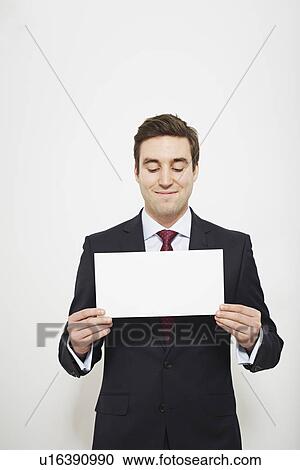 Stock Image - Businessman holding blank card. Fotosearch