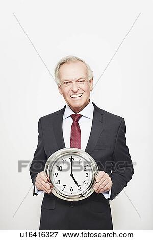 Stock Photo - Businessman holding clock. Fotosearch