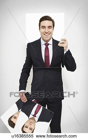 Stock Photography - Businessman holding happy picture over his face. Fotosearch