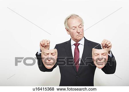 Stock Photo - Businessman holding masks. Fotosearch