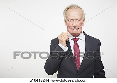 Picture - Businessman holding picture over his mouth. Fotosearch
