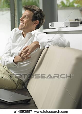 Businessman on sofa in office lobby View Large Photo Image Stock Photo - Businessman on sofa in office lobby. Fotosearch