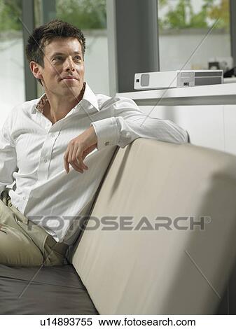 Businessman on sofa in office lobby View Large Photo Image Stock Photography - Businessman on sofa in office lobby. Fotosearch