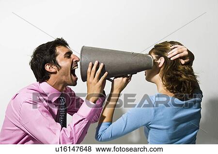 Stock Photo - Businessman shouting into colleagues ear. Fotosearch