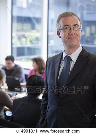 Businessman smiling in office View Large Photo Image Stock Image - Businessman smiling in office. Fotosearch