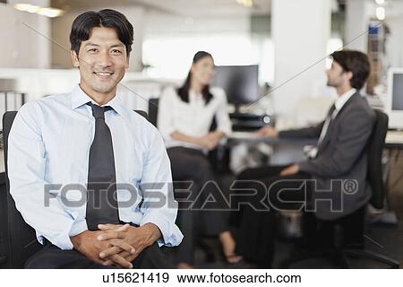 Stock Photo - Businessman smiling in office. Fotosearch