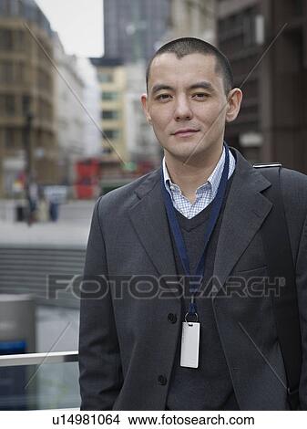 Picture - Businessman standing on city street. Fotosearch