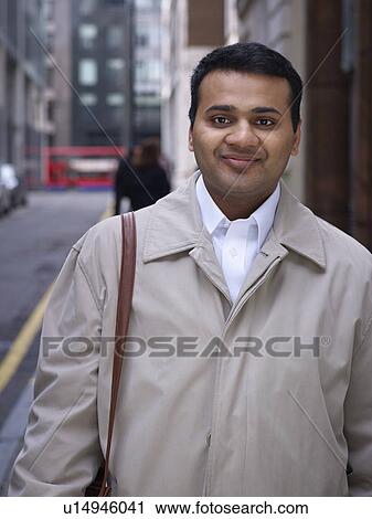 Stock Image - Businessman standing on city street. Fotosearch