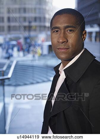 Businessman standing on city street View Large Photo Image Stock Photo - Businessman standing on city street. Fotosearch
