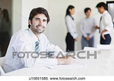 Businessman taking notes in meeting View Large Photo Image Stock Photography - Businessman taking notes in meeting. Fotosearch