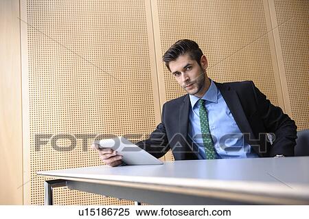 Businessman using tablet computer at desk View Large Photo Image Stock Photography - Businessman using tablet computer at desk. Fotosearch