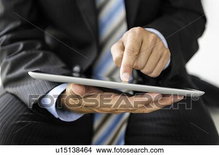 Businessman using tablet computer View Large Photo Image Picture - Businessman using tablet computer. Fotosearch