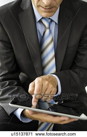 Stock Image - Businessman using tablet computer. Fotosearch