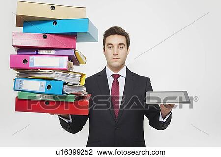 Stock Image - Businessman with stacks of folders and tablet computer. Fotosearch