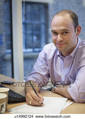 Businessman working at desk View Large Photo Image Picture - Businessman working at desk. Fotosearch