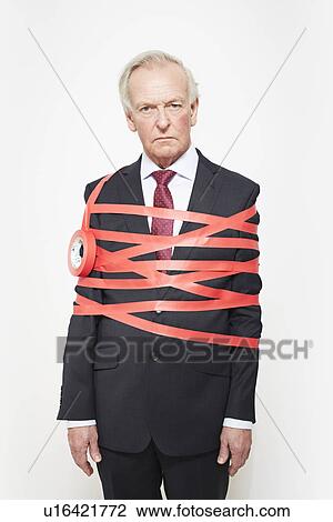 Stock Image - Businessman wrapped in red tape. Fotosearch