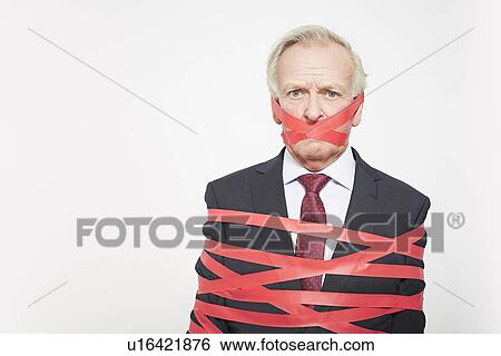 Businessman wrapped in red tape View Large Photo Image Stock Photograph - Businessman wrapped in red tape. Fotosearch