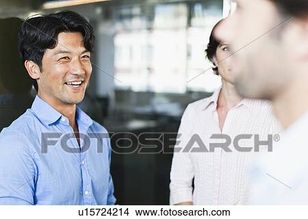 Picture - Businessmen smiling at each other. Fotosearch