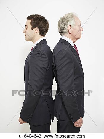 Businessmen standing back to back View Large Photo Image Stock Image - Businessmen standing back to back. Fotosearch