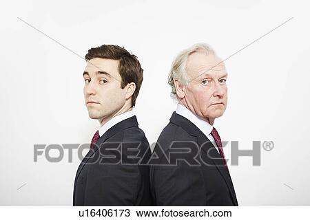 Businessmen standing back to back View Large Photo Image Stock Image - Businessmen standing back to back. Fotosearch