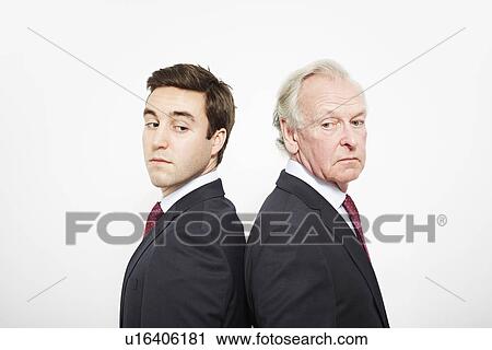 Stock Image - Businessmen standing back to back. Fotosearch