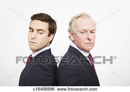 Businessmen standing back to back View Large Photo Image Stock Photograph - Businessmen standing back to back. Fotosearch