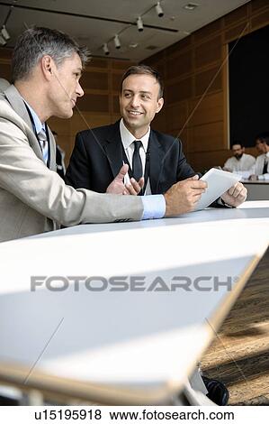 Businessmen using tablet computer at desk View Large Photo Image Stock Photo - Businessmen using tablet computer at desk. Fotosearch