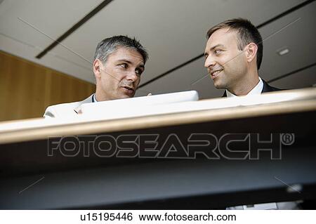 Businessmen using tablet computer at desk View Large Photo Image Stock Photograph - Businessmen using tablet computer at desk. Fotosearch
