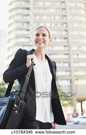 Businesswoman carrying briefcase outdoors View Large Photo Image Stock Photograph - Businesswoman carrying briefcase outdoors. Fotosearch