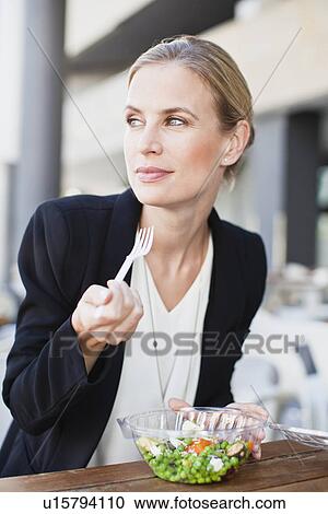 Businesswoman eating salad outdoors View Large Photo Image Stock Image - Businesswoman eating salad outdoors. Fotosearch