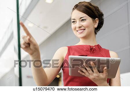 Businesswoman holding tablet computer View Large Photo Image Stock Image - Businesswoman holding tablet computer. Fotosearch