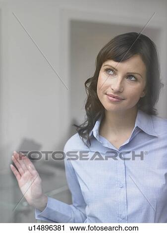 Businesswoman looking out office window View Large Photo Image Stock Image - Businesswoman looking out office window. Fotosearch