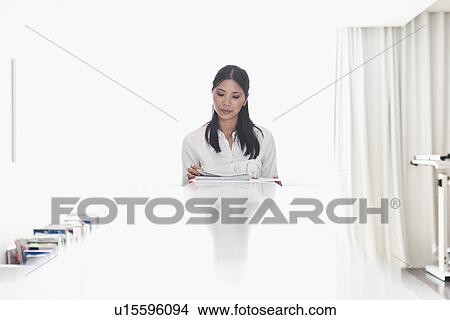 Businesswoman reading at desk View Large Photo Image Picture - Businesswoman reading at desk. Fotosearch