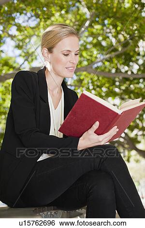 Businesswoman reading book outdoors View Large Photo Image Stock Photograph - Businesswoman reading book outdoors. Fotosearch