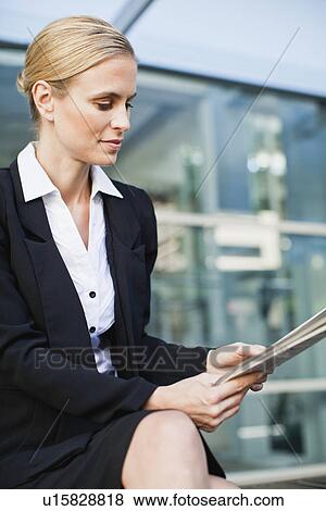 Stock Photo - Businesswoman reading newspaper. Fotosearch