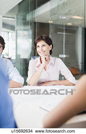 Picture - Businesswoman sitting in meeting. Fotosearch