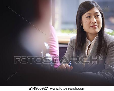 Stock Photo - Businesswoman sitting in meeting. Fotosearch
