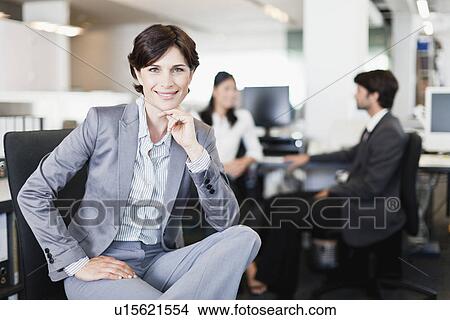 Picture - Businesswoman smiling in office. Fotosearch