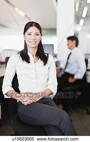 Stock Photography - Businesswoman smiling in office. Fotosearch