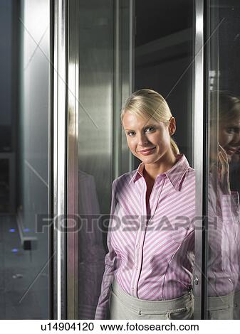 Stock Image - Businesswoman standing in doorway. Fotosearch