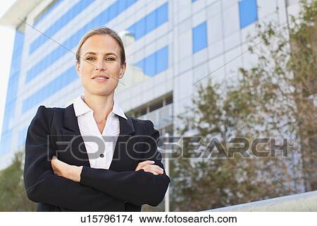 Picture - Businesswoman standing on city street. Fotosearch